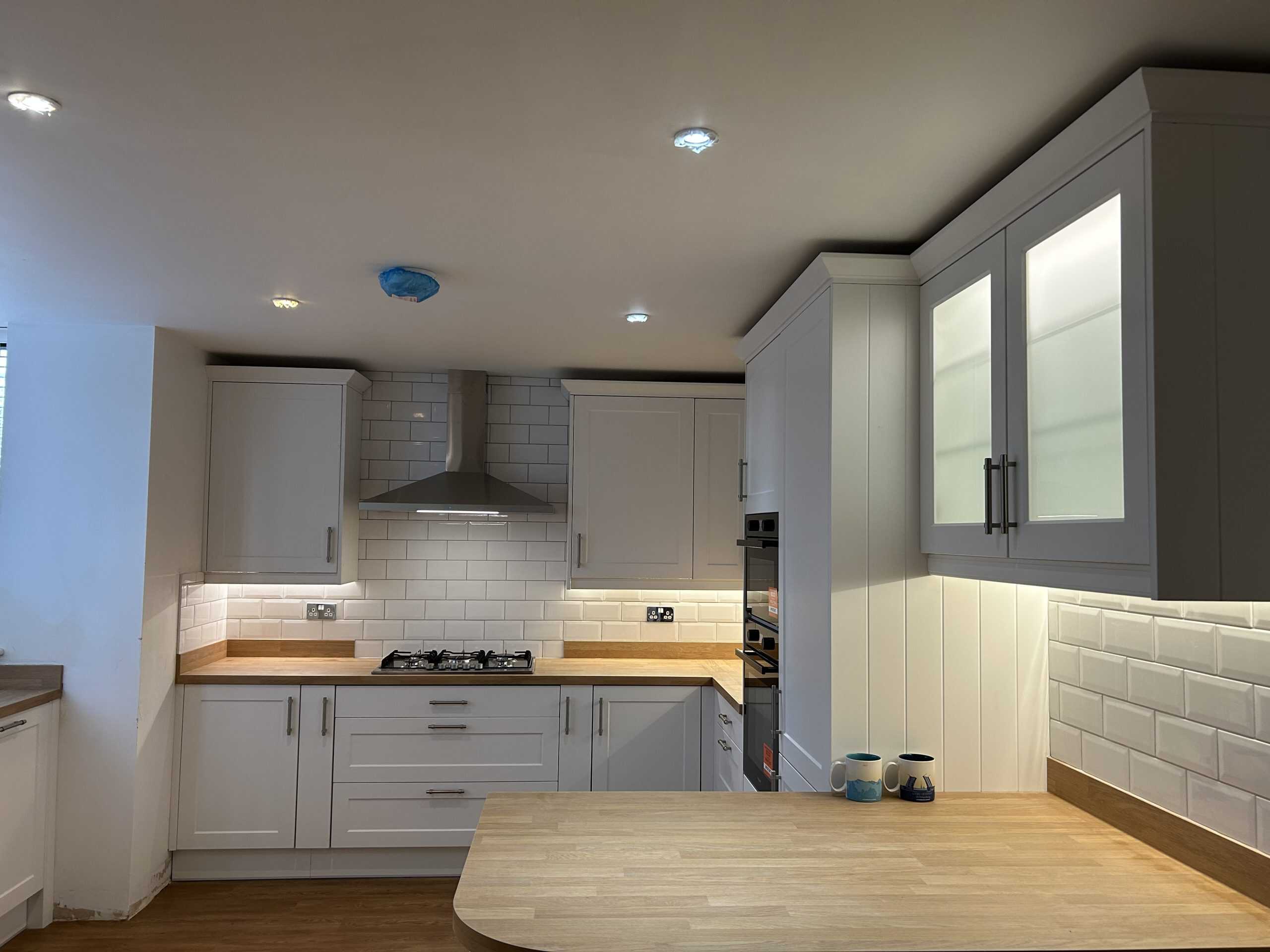 Modern kitchen with white cabinets, wooden countertops, and subway tile backsplash.