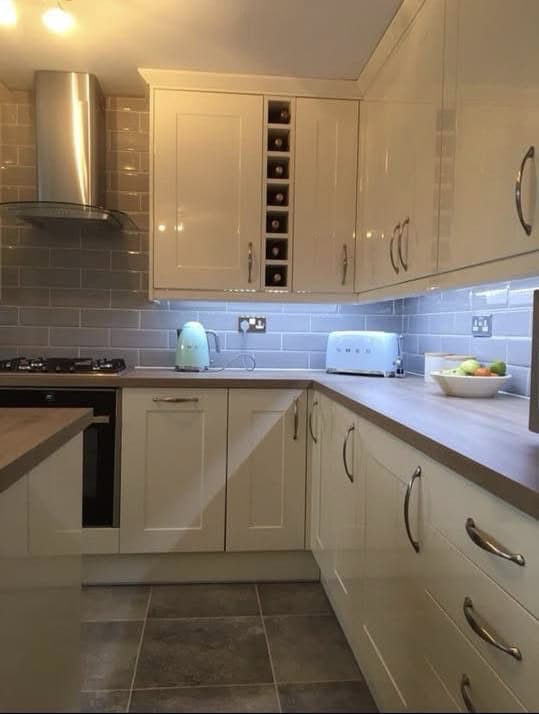 Modern beige kitchen with built-in cabinets, oven, and appliances for a sleek cooking space.