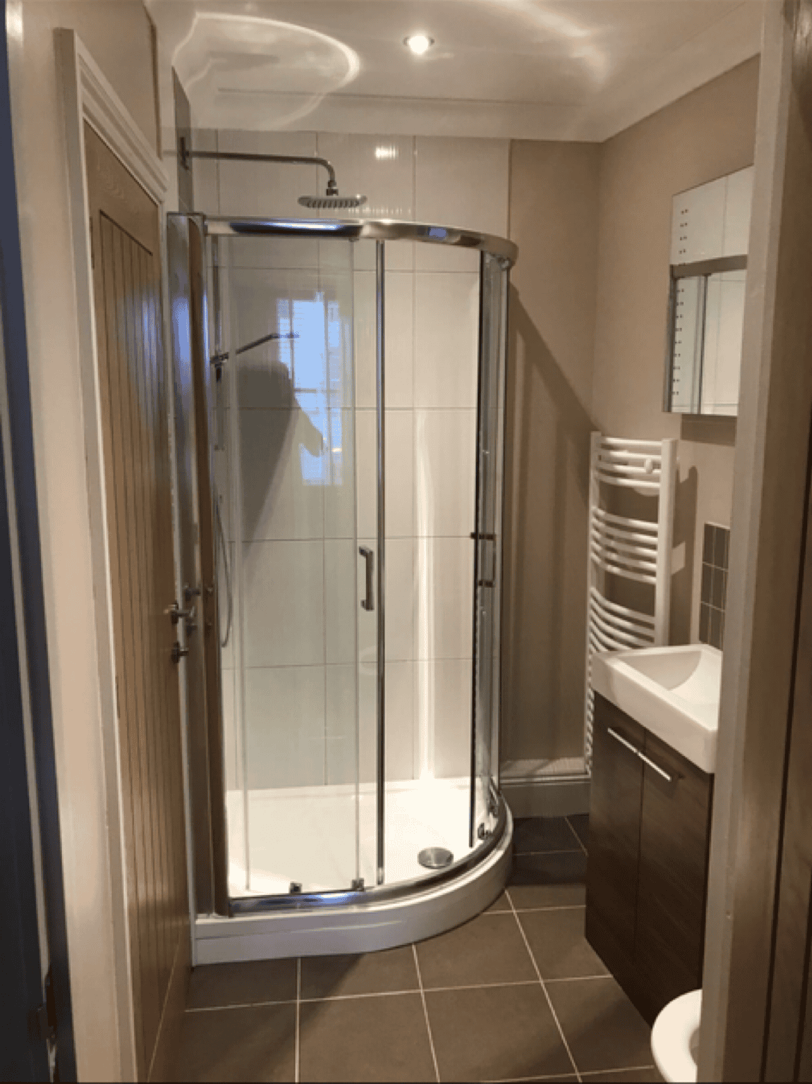 Shower enclosure with glass doors in a contemporary bathroom setting.