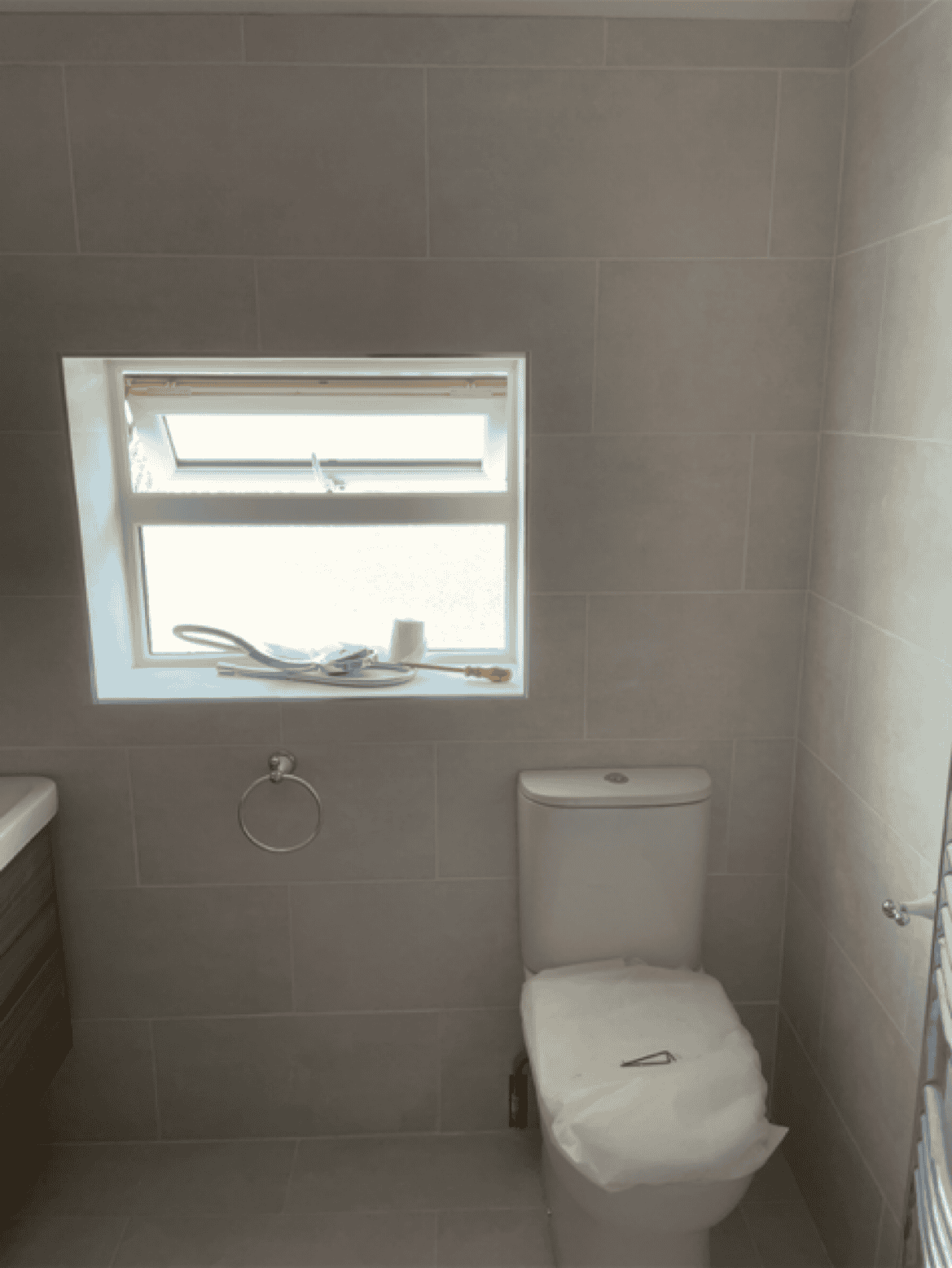 Bathroom with new toilet and window for natural light and ventilation.